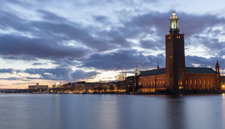 Stockholms stadshus vid vattnet i Stockholm, Sverige, med upplyst torn i kvällsljus