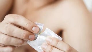 Person öppnar en kondomförpackning – symbol för säkert samlag och preventivmedel