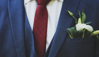 Man i kostym med röd slips och blomma – symbol för elegans, maskulinitet och sexleksaker för honom