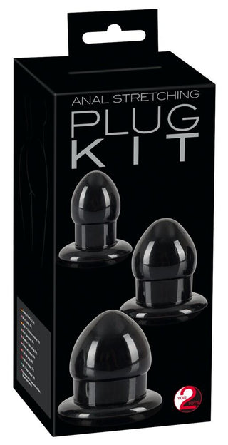 Anal Stretching Plug Kit kommer i en svart låda med ett handtag, med tre storlekar av svarta analpluggar för säker stimulering, och innehåller flerspråkig text på sidan.