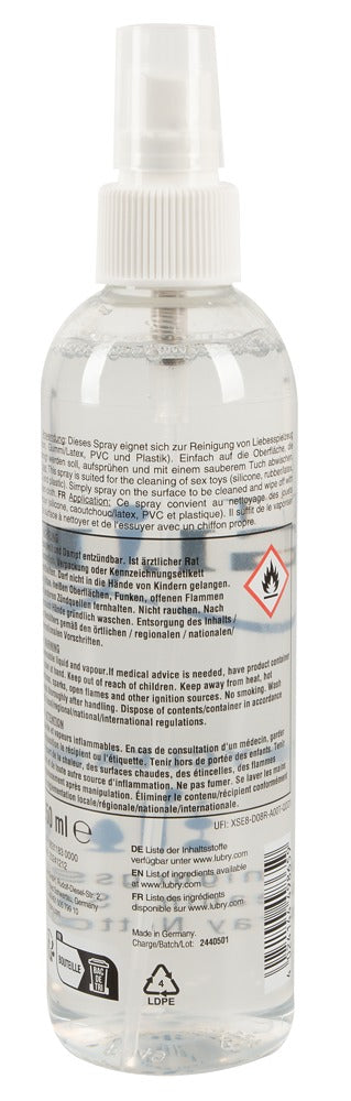 Just Glide Rengöringsspray 250ml är en klar sprayflaska med flerspråkiga varningsetiketter och instruktioner, med en alkoholbaserad formula för säker rengöring av sexleksaker.