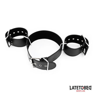 Latetobed Neck & Wrist Cuff har svarta läderfästen med tre justerbara manschetter som är sammanlänkade med metallringar - perfekt som bondagehalsband eller halsband med handbojor för kreativ lek. Visas på en vit bakgrund.