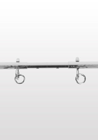 En Taboom Bondage Spreader Bar i krom med ankelmanschetter och två metallkrokar, mot en vanlig vit bakgrund.