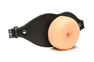 Ass Face Mun-Gag Beige är en läderrem med en beige silikoninsats, munformad och BDSM-inspirerad, som visas på en vit bakgrund.