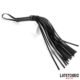 Latetobed Flogger 52 cm är en BDSM-flogger i svart läder med flera svansar och ett handtag med ögla, som visas på en vit bakgrund för varierad stimulering.
