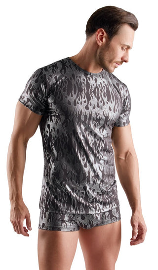 En man iförd Svenjoyment Metallic Shirt och matchande shorts med silverglänsande mönster tittar ner till höger om sig.
