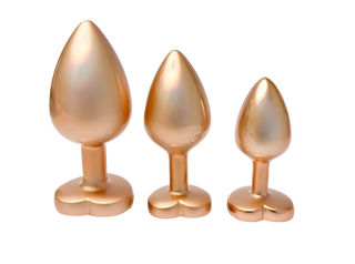 Pärlguld Buttplug Set 3-pack innehåller tre guldfärgade, hjärtformade buttplugs i olika storlekar, elegant arrangerade som ett perfekt matchande set för din samling.