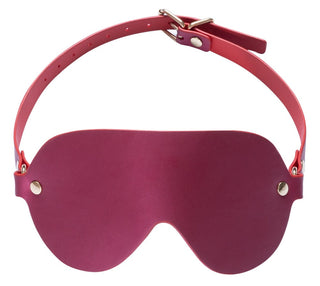 En rosa ögonmask tillverkad av rosa imitationsläder, med ett justerbart band och metallnitar - perfekt att kombinera med Luxury Pearl Bondage Kit.