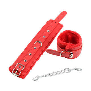 Latetobed Fur Handcuffs har rött foder av fuskpäls, metallspänne och kedjekoppling - perfekt för nybörjare eller för den som vill addera lyx till sin BDSM-samling. Visas utlagda på en vit bakgrund.
