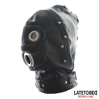 Total Lockdown BDSM Mask har svart läder, ögon- och munöppningar i metall, en krage med spänne och märkningen LATETO BED BDSM LINE - perfekt för sensorisk begränsning och intensiva rollspelsscenarier.