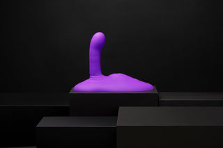 En lila, abstrakt Cowgirl Rodeo Rider Thrusting-skulptur i kroppssäkert silikon står upprätt på en svart plattform mot en mörk bakgrund.