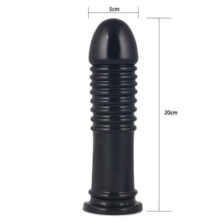 Svart, ribbad analplugg i kroppssäker PVC, 20 cm lång och 5 cm bred, avbildad stående på en plan yta.
