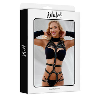 En leende kvinna visar upp Adalet Kianna Body Harness med svarta remmar och justerbart frontband på en märkesförpackning.