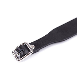 Närbild av Svart BDSM Halsband 43 cm, ett svart justerbart läderhalsband med silverspänne, mot en vit bakgrund.
