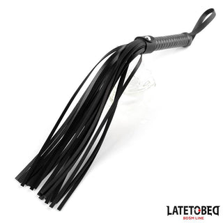 Latetobed Flogger 52 cm är en flogger i svart läder med flera svansar och ett handtag med ögla, perfekt för varierad stimulering.