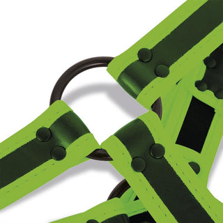 Närbild av neongröna och svarta remmar med svarta nitar och en rund svart metallring, tillverkade av veganskt läder för en slående Shining Line Glow Bondage Harness som lyser i mörkret.