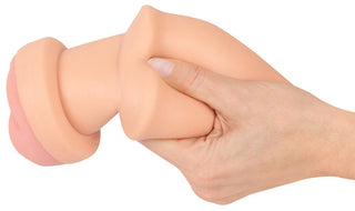 En hand som håller i den realistiska, köttfärgade 2in1 Buttplug Extension silikonmodellen, avsedd att användas som masturbator.