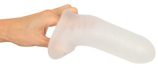 En hand håller Rebel Penissleeve Med Kulring, en stor, genomskinlig, gummiaktig penissleeve.
