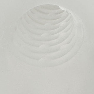 En cirkelformad fördjupning med koncentriska åsar i vitt pulver, som liknar ett fingeravtryck eller en krater, ungefär som den strukturerade ytan på Rebel Penissleeve Med Kulring.