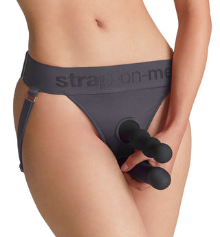 Strap-on-strumpa i grått tyg med öppning framtill, som visar sig hålla en svart trekantig silikondildo.