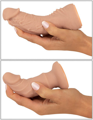 Två händer som håller och böjer en realistisk, flexibel, köttfärgad dildo från vår Strap-on Set med Vibrator-kollektion.