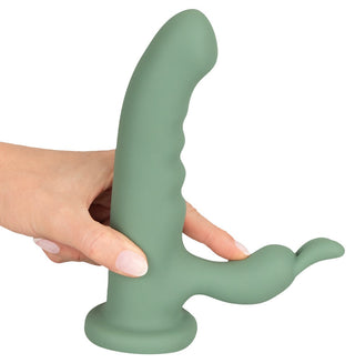En hand håller LUVIO Soft Rotating Rabbitvibrator, tillverkad av mjuk silikon, med ett grönt böjt huvudskaft och en mindre förlängning för dubbel stimulering.