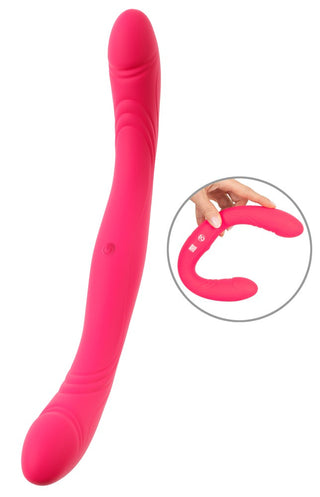 Couples Choice Double Vibrator är ljusrosa och flexibel med två rundade spetsar, som visas böjda i en handinsats.