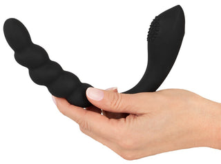 En hand som håller i Bendable Dual Stimulator, en svart, böjd silikonvibrator med en texturerad ände.