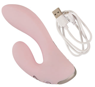 A CERYA Rabbitvibrator i rosa för vaginal och klitorisstimulans ligger på vit bakgrund med en USB-laddningskabel bredvid.
