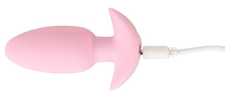Cuties Mini Vibrating Plug är en rosa, uppladdningsbar mini butt plug med en utsvängd bas för nybörjare, här ansluten till sin vita laddningskabel.