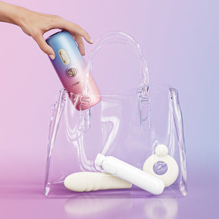 Lovense Spinel vibrator, rosa silikon med ergonomisk design, placerad i en genomskinlig handväska bredvid vita personliga enheter.