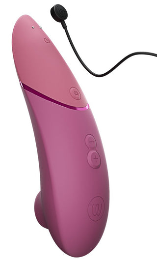 Klitorisstimulator i rosa silikon med kontrollknappar, magnetisk laddningsport och en mjuk, böjd design.