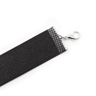 Närbild av Black Bow BDSM Collar: ett halsband i svart tyg med silverlås, med en svart rosett på vit bakgrund. Bär som ett justerbart halsband eller som en elegant BDSM-halsbandsaccessoar.