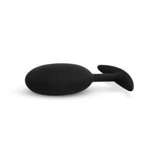 Upptäck Buttplug Med Tyngd Medium, en svart analplugg tillverkad av kroppsäkert silikon med en elegant, ergonomisk design mot en vanlig vit bakgrund.