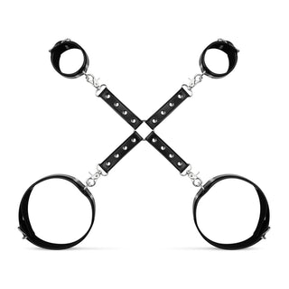 Cuffs & Hogtie Set har svart läder handled och ankel manschetter i X-form, med justerbara manschetter och slitstarka PVC- och PU-läder-kontakter på en orörd vit bakgrund.