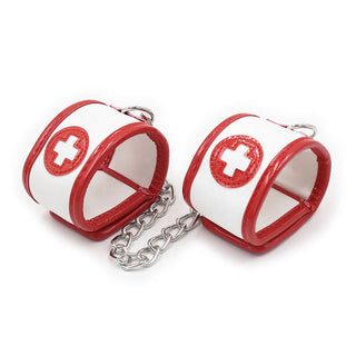 Det spännande Ohmama 3-delade Nurse Bondage Setet innehåller röda och vita manschetter sammanlänkade med en metallkedja, prydd med ett rött kors, perfekt för sjuksköterskans rollspel.