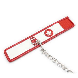 Ohmama 3-delade Nurse Bondage Set innehåller en röd och vit rem med en medicinsk korssymbol, perfekt för rollspel. Den har metalldubbar och fästs på en metallkedja, allt mot en vanlig vit bakgrund.