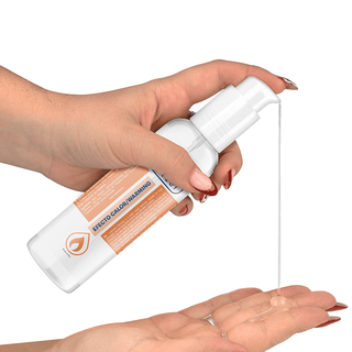 En person doserar Heat Effect Lubricant 150 Ml från en pumpflaska på sin handflata mot en vit bakgrund.
