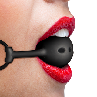 Närbild av en person med rött läppstift som bär Fetish Submissive Silicone Ball Gag med justerbar rem i munnen.