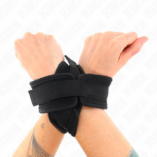 Svarta vadderade Cross Cuffs Svarta 34 cm fasthållningsanordningar med fästklämmor, visade mot en slät bakgrund.