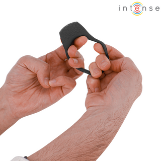Två händer håller i och sträcker ut en liten svart Intense Clover Fjärrstyrd Penisring, med "intense" skrivet i övre högra hörnet.