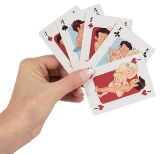 En hand som håller ett Kortspel - Kama Sutra-kortlek, med humoristiska tecknade illustrationer, ger en lekfull twist till det klassiska spelet.