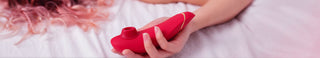 Kvinna håller en röd lufttrycksvibrator – innovativa lufttrycksvibratorer för intensiv klitorisstimulering