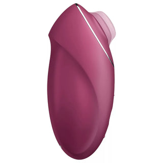 Rödbrun handhållen stimulator med böjd ergonomisk design och liten cirkulär spets, tillverkad av slätt material.