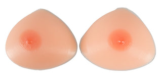 Två "Lösbröst Av Silikon" med ljus hudton och rosa areolas vilar sida vid sida på en vit bakgrund, perfekt för att förhöja ditt utseende eller lägga till stil till kostymer.
