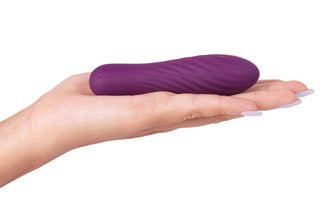 En hand håller Tulip Bullet Violett, en liten och slät lila vibrator för sensuell stimulering.