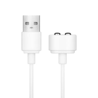 Närbild av en vit USB-laddningskabel med en USB-kontakt i ena änden och en magnetisk tvåstiftskontakt i den andra, designad för Teazers Vibrator med slickande klitorisstimulator, mot en vanlig vit bakgrund.