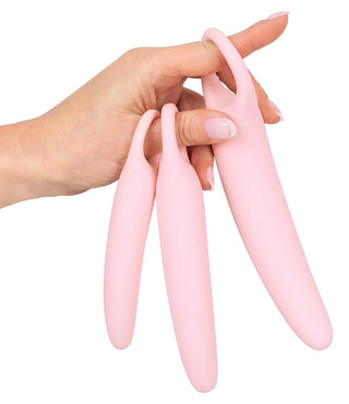 En hand visar tre rosa silikonfingerärmar med öglor, perfekt för ditt Vaginal Trainers Set.