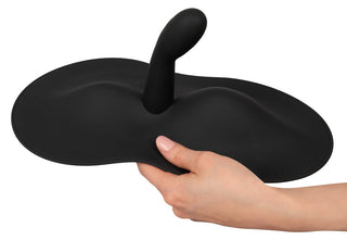 En hand tar tag i den eleganta svarta Vibepad 3, med ett centralt utskjutande handtag och en distinkt vågliknande bas, som förkroppsligar konstnärskap i rörelse.